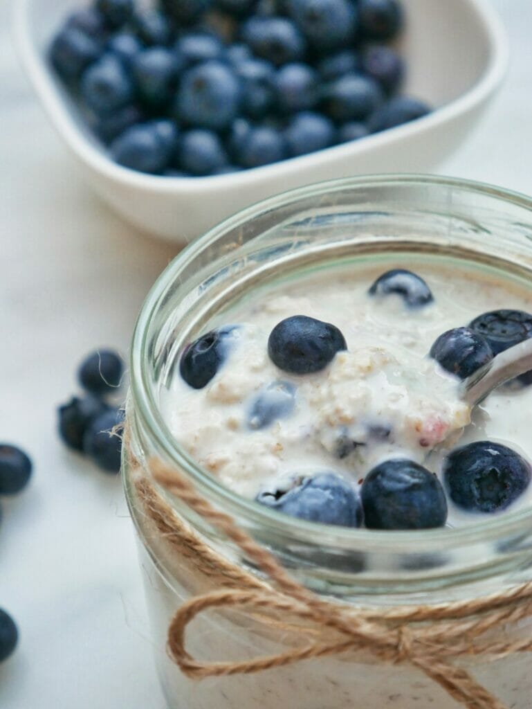 blueberry overnight oats in mason jar with spoon