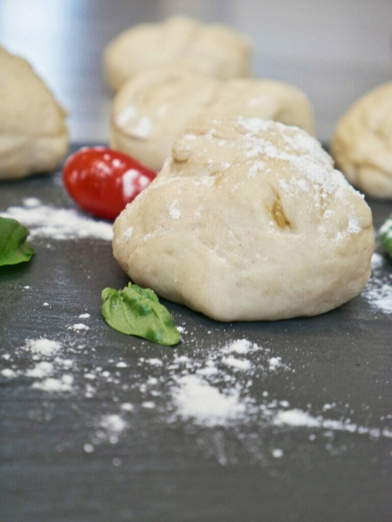 ball of uncooked pizza dough with flour on it