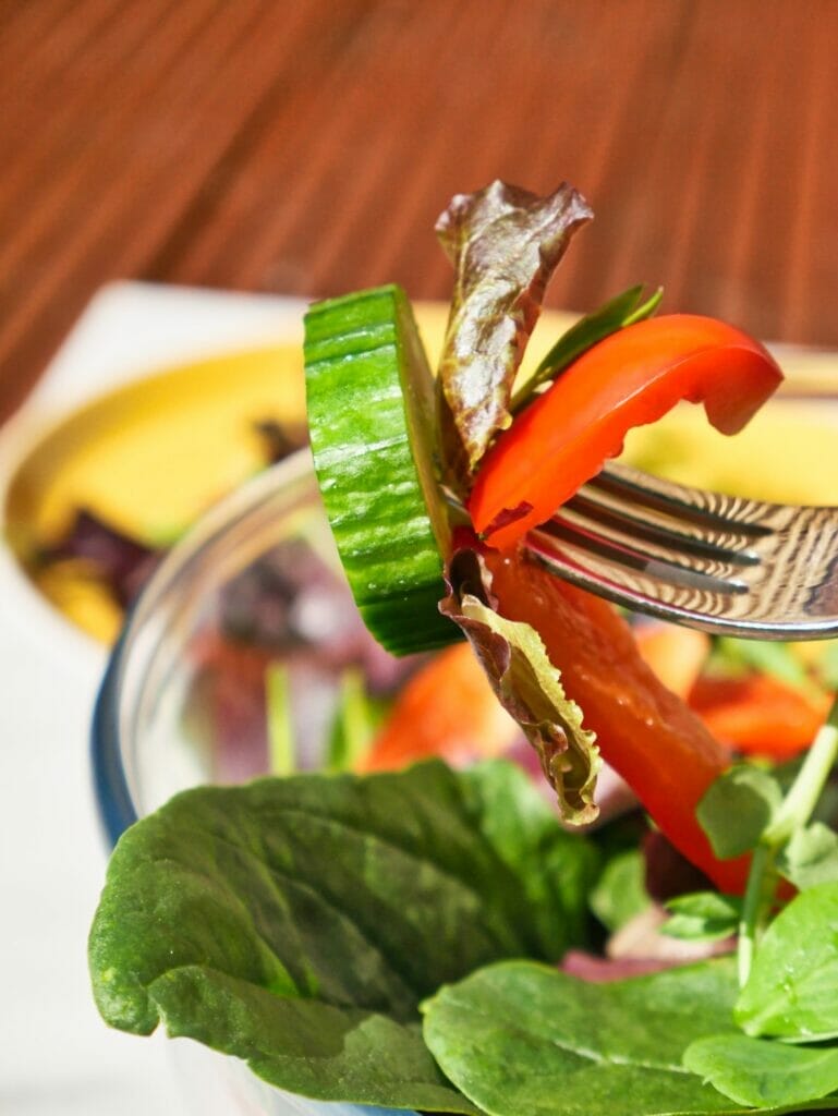 fork holding cucumber and red bell pepper