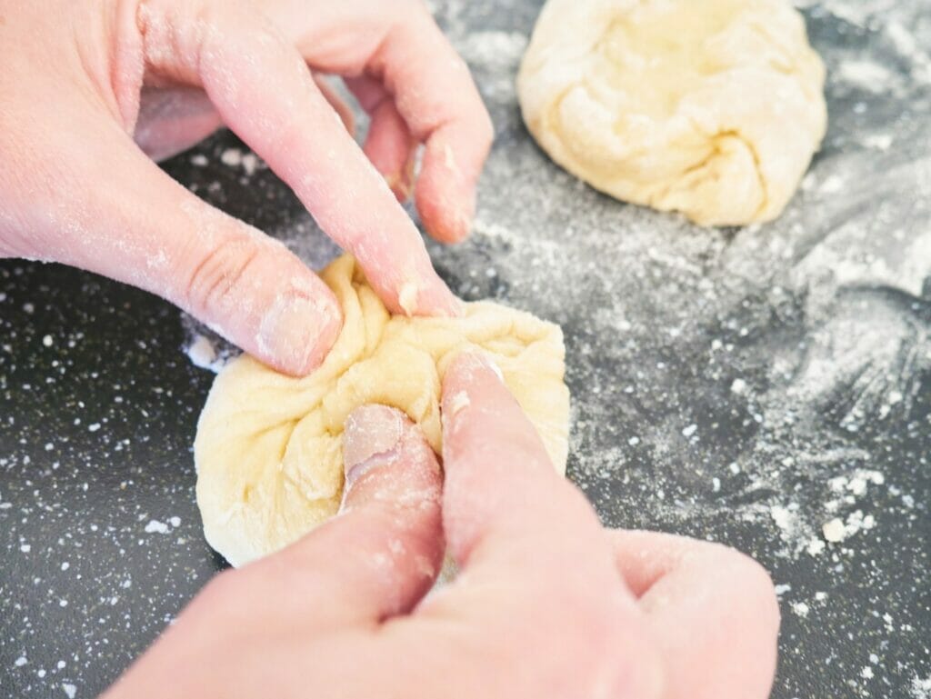 pinching brioche bun dough together