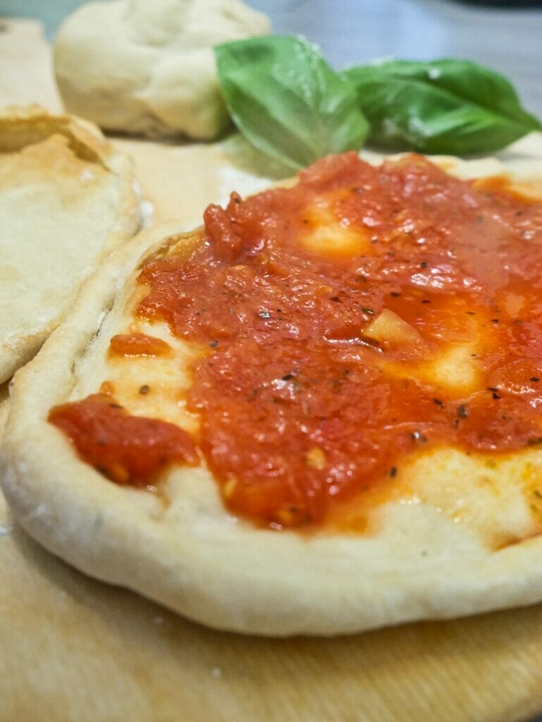 individual pizza crust with tomato sauce