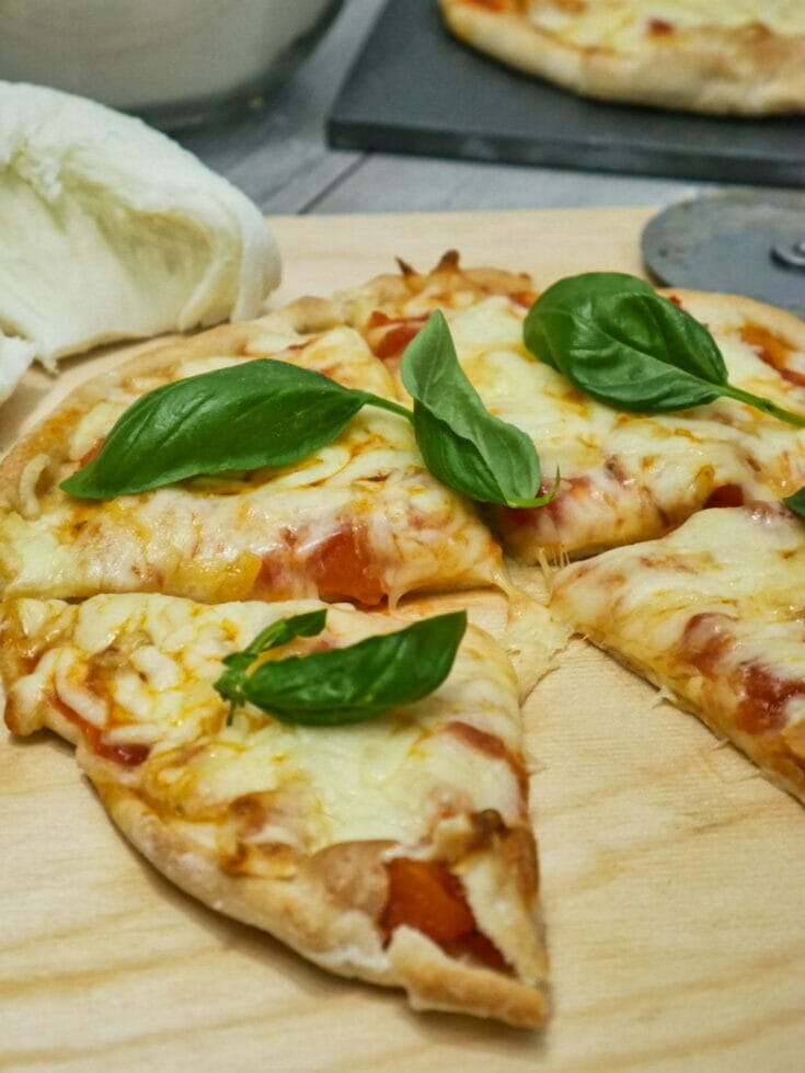 individual pizza with basil leaves