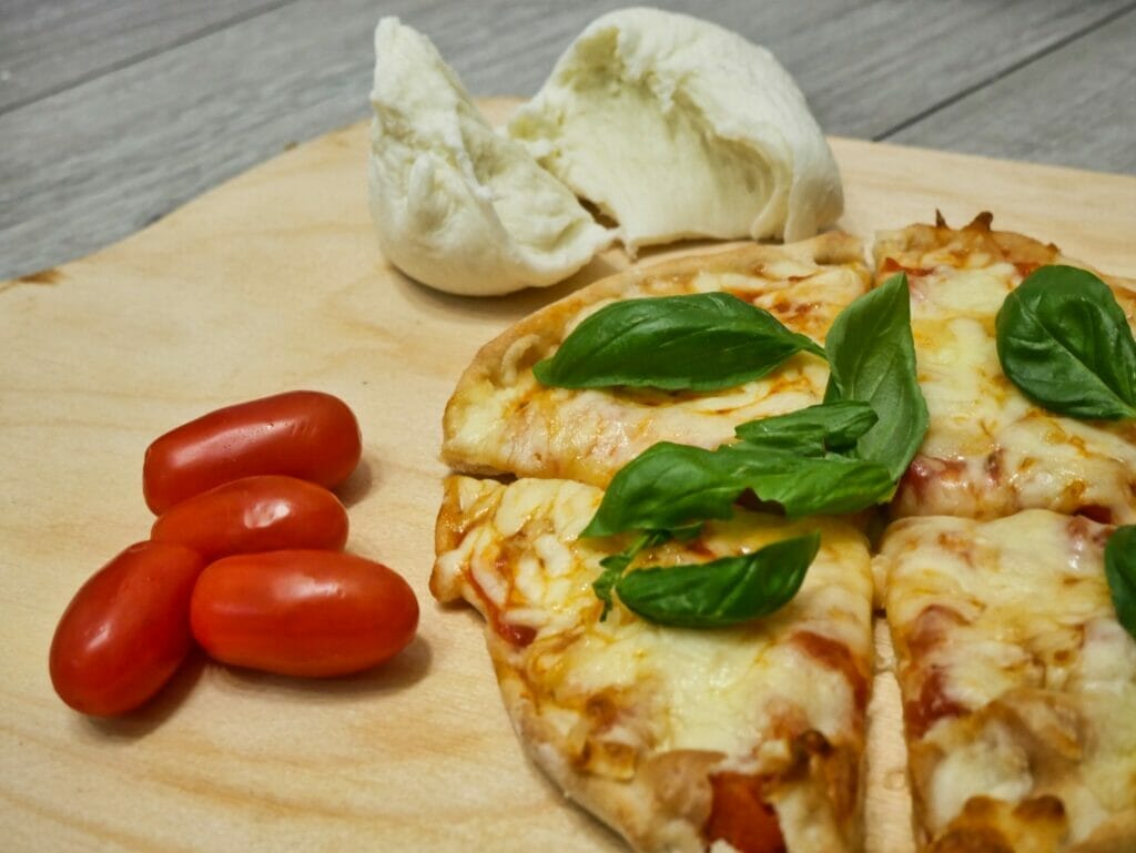 individual pizza with basil leaves