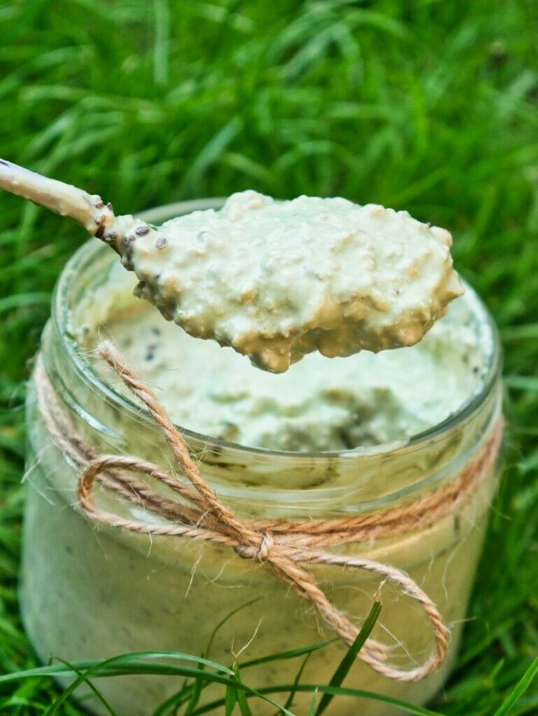 matcha overnight oats in grass with spoon
