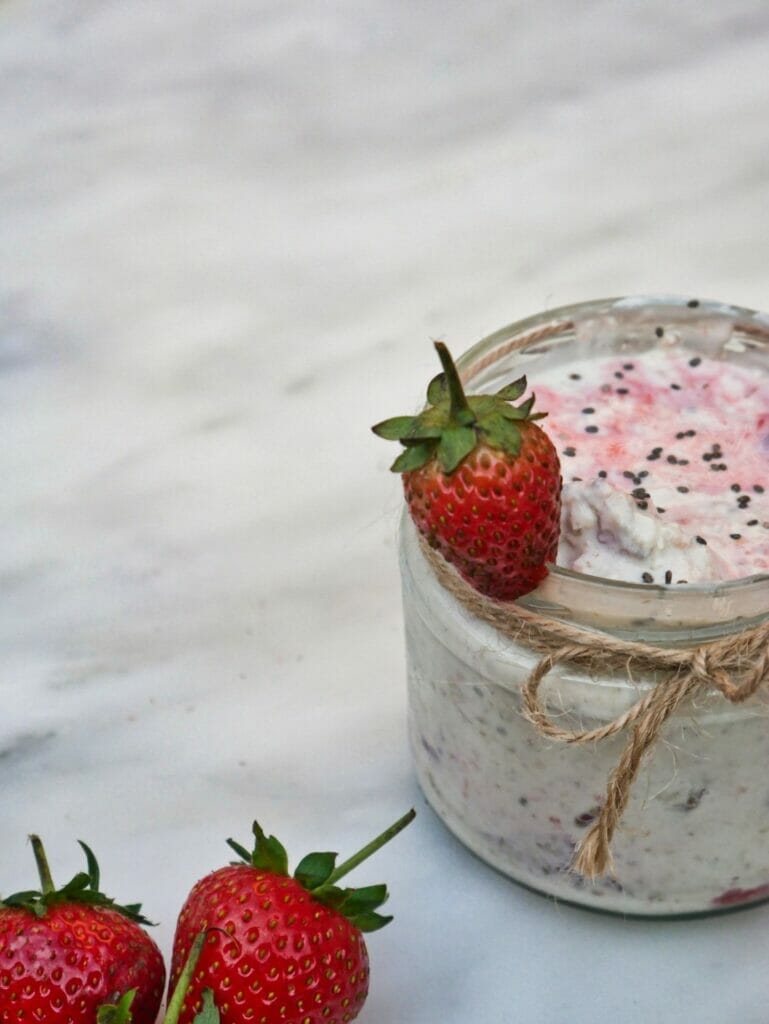 strawberry overnight oats with strawberry on rim
