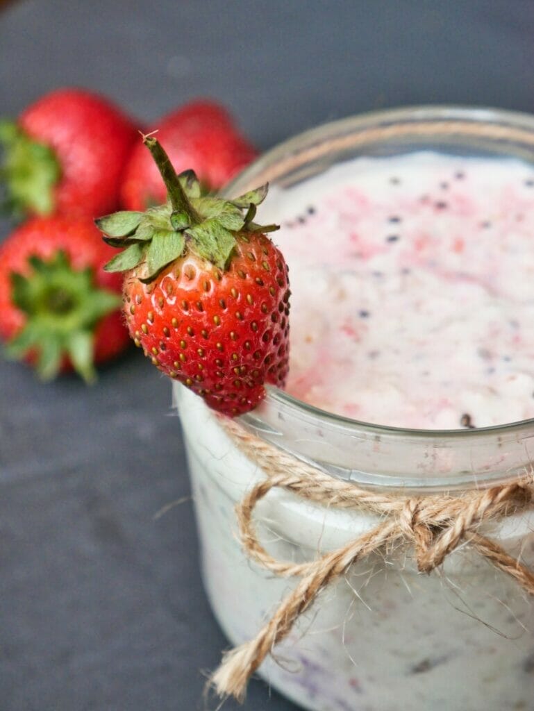 strawberry on rim of overnight oats jar