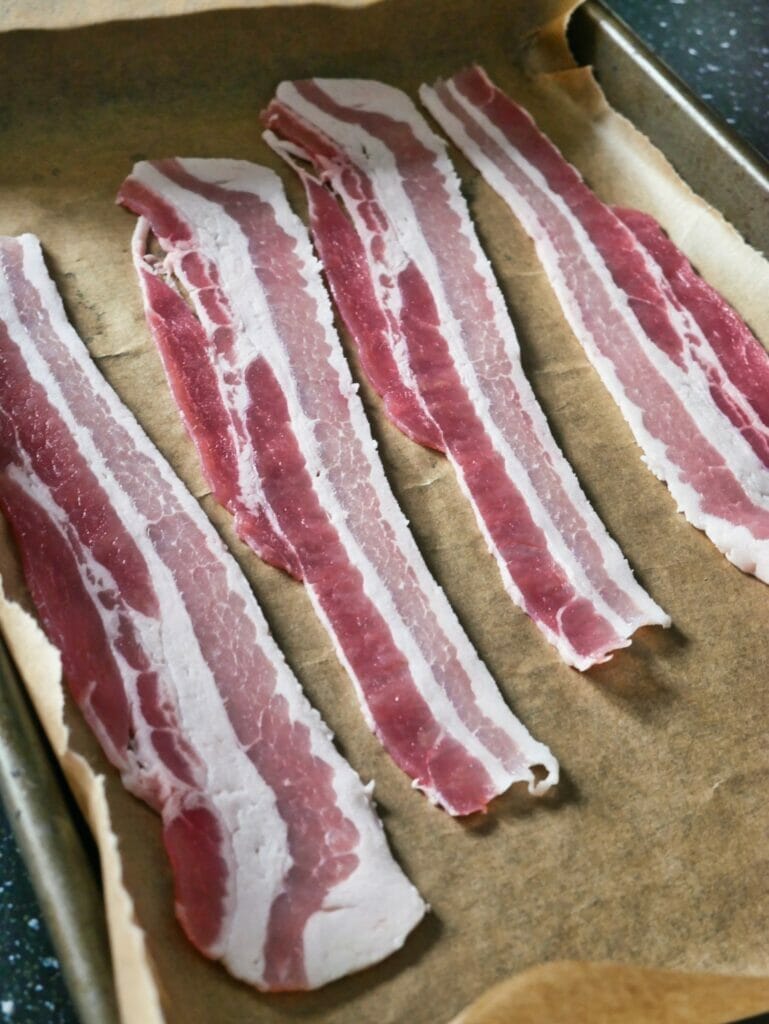 raw bacon on parchment paper