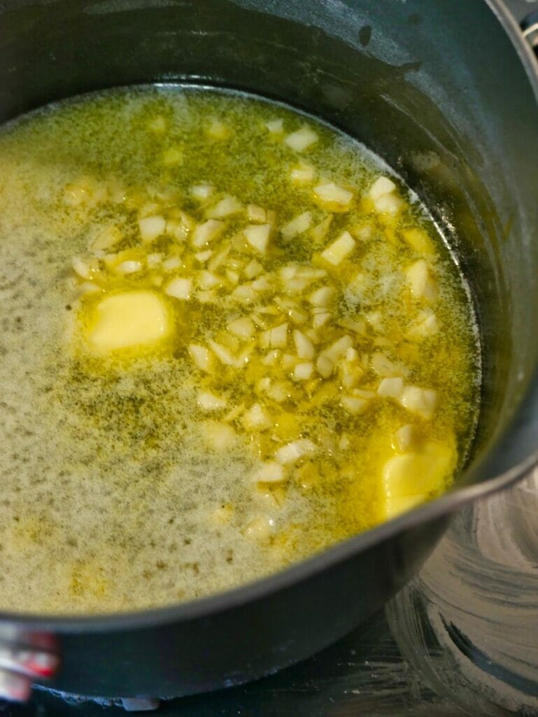 butter melting in pot with garlic