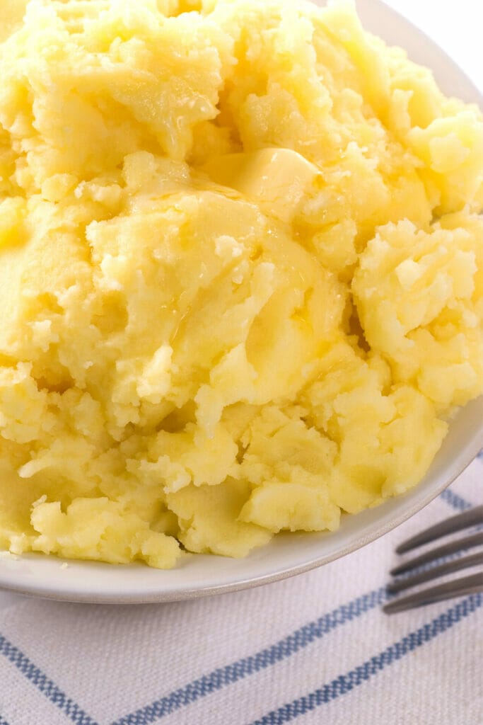 Close up image of mashed potatoes on a table with a fork 