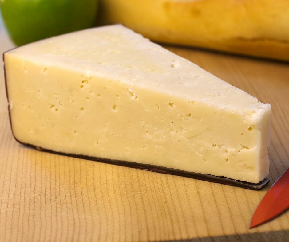 Asiago Pressato with a knife next to it