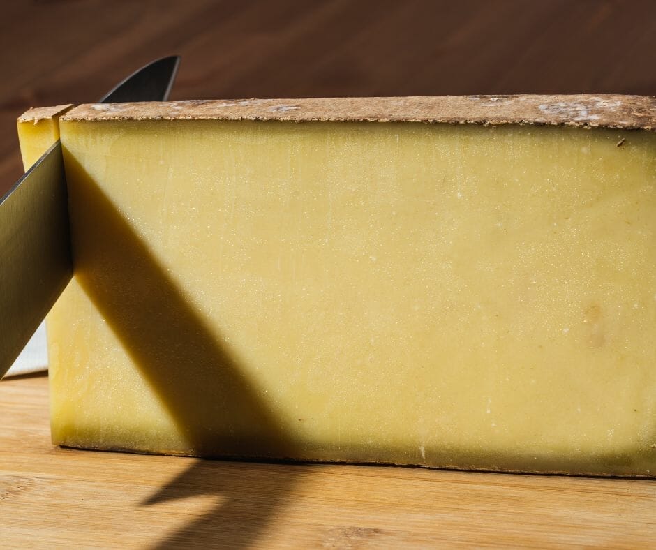 Knife slicing Comte cheese