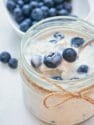 blueberry overnight oats with spoon in mason jar